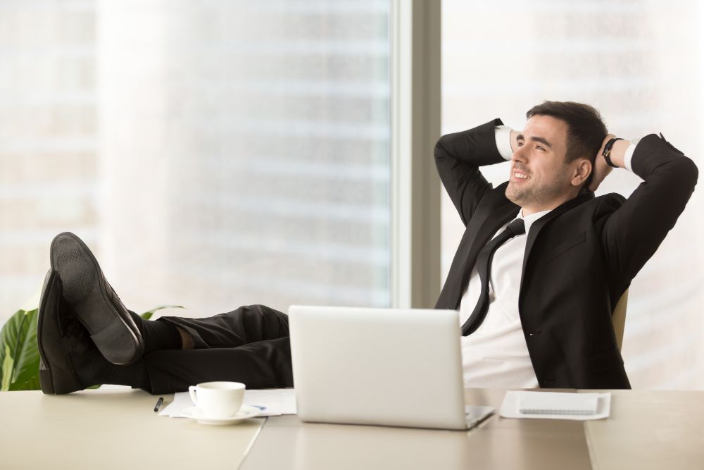 Company Director Relaxing at Workplace in Office