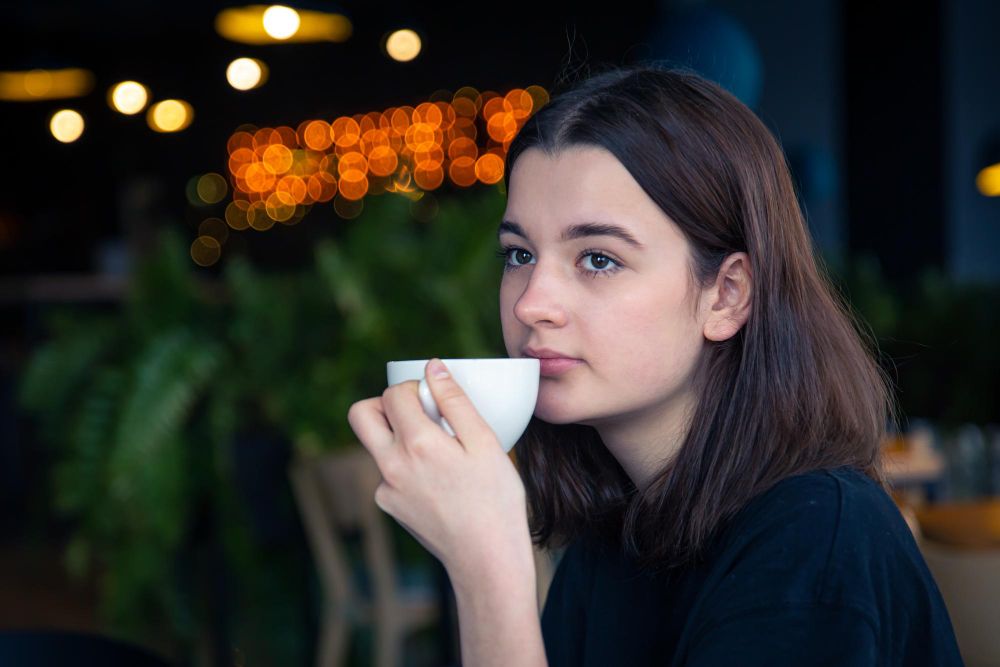 Portrait of a young woman with a cup of tea in a cafe