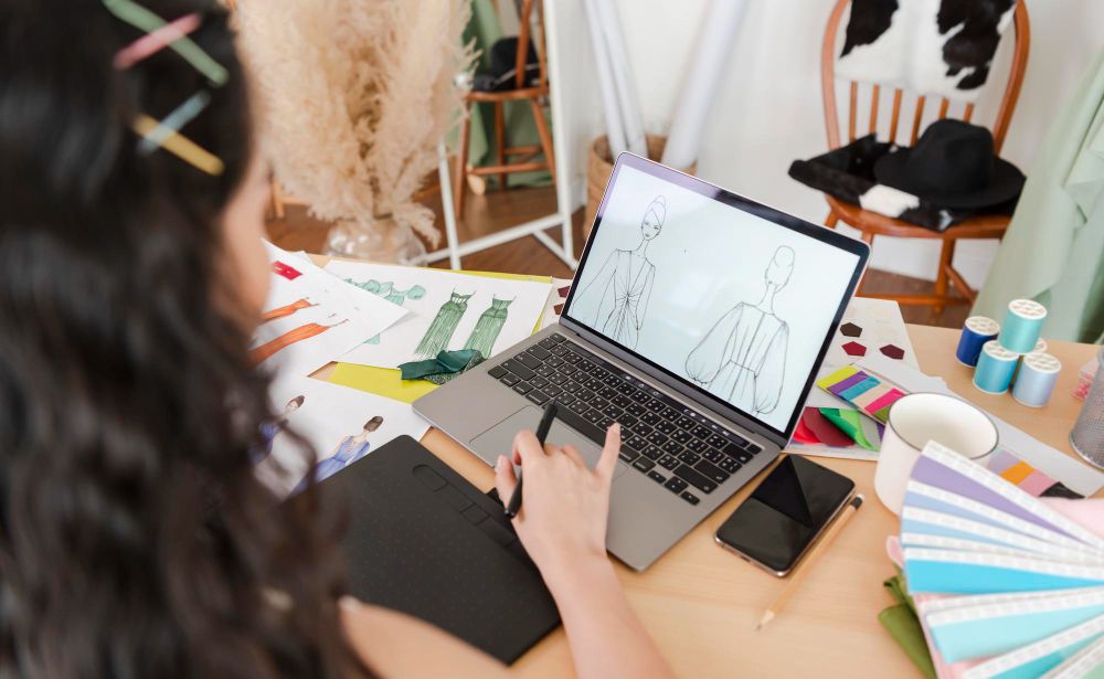 A Designer Drawing Sketches for New Collection on Computer Laptop