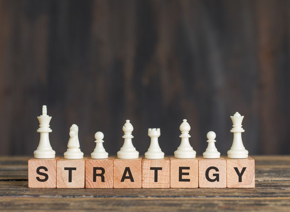 Business Strategy Concept With Chess Pieces on Wooden Cubes on Wooden Table Side View