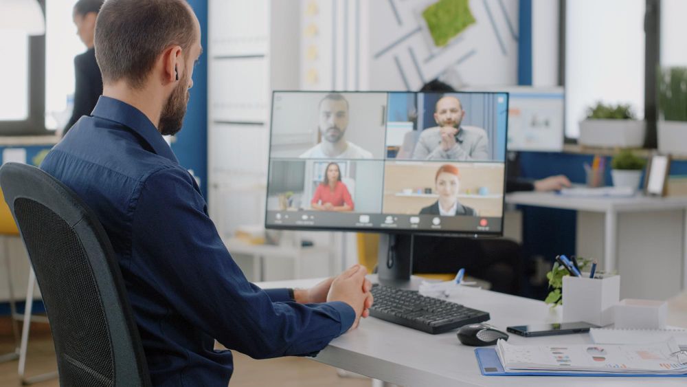 Businessman Talking to Team of Colleagues on Video Call